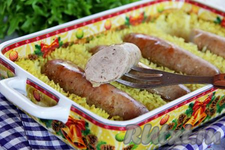 Готовое блюдо достать из духовки. Сочные, нежные купаты вместе с рассыпчатым рисом разложить по тарелкам и в горячем виде подать к столу.