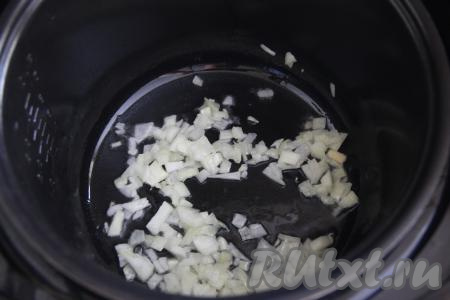 Влить в чашу мультиварки растительное масло, выставить на 15 минут режим "Жарка". Лук мелко нарезать и выложить в чашу мультиварки, обжаривать его до прозрачности (ориентировочно в течение 4-5 минут), иногда помешивая.