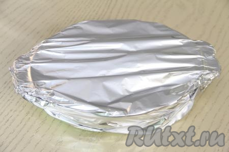 Накрыть форму фольгой и поставить в разогретую до 200 градусов. Запекать кусочки минтая под шубой в сметане с морковью и луком 30 минут. 