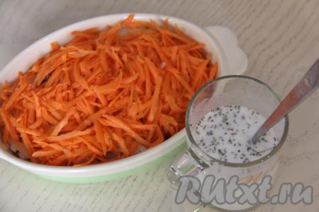 Морковь натереть на крупной тёрке, разложить поверх лука. В отдельной ёмкости соединить 100 миллилитров воды, сметану, соль и специи, очень хорошо перемешать получившийся сметанный соус.