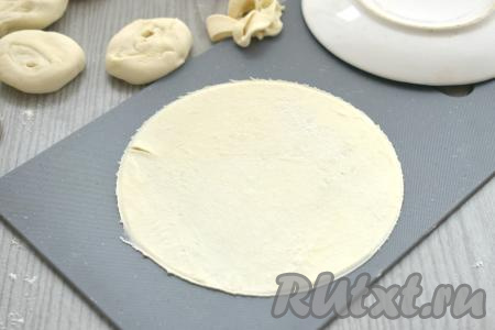 На припылённой мукой поверхности кусочки теста раскатываем скалкой в тонкие лепёшки диаметром примерно 15 сантиметров. При желании края раскатанных лепёшек можно подровнять с помощью блюдца такого же диаметра.
