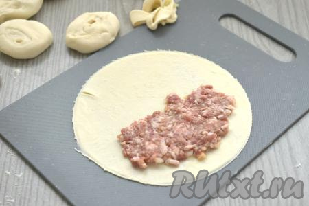 Фарш для чебуреков зрительно делим на 8 равных частей. На одну сторону лепёшки, отступая от краёв по 1 сантиметру, выкладываем одну часть мясного фарша.