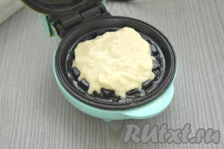 Панели электровафельницы смазываем растительным маслом, разогреваем. На нижнюю панель кладём 1,5-2 столовых ложки яблочного теста. Накрываем верхней панелью.