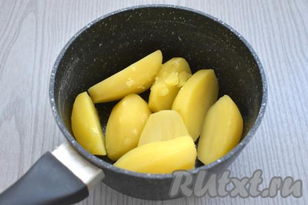 Очищаем картофель, разрезаем пополам, складываем в кастрюлю, заливаем полностью холодной водой, ставим на сильный огонь. После закипания варим картофель в подсоленной воде до готовности (ориентировочно минут 20-25, готовая картошка будет легко прокалываться ножом). Затем выливаем воду, в которой варился картофель.
