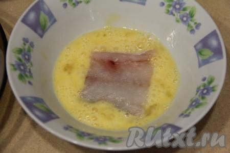 Обмакнуть филе минтая в яйцо с двух сторон.