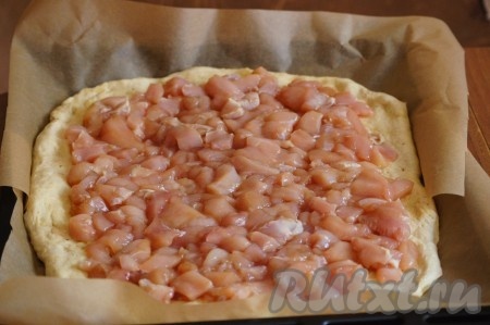 Куриное филе нарезаем на кусочки, добавляем соевый соус, перчим и оставляем минут на 20. Раскладываем куриное филе на тесто ровным слоем.