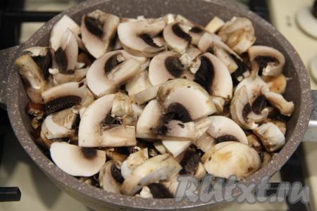 Пока тушится мясо, на отдельную сковороду, разогретую с растительным маслом, выложить нарезанные шампиньоны. Обжарить грибы, время от времени помешивая, в течение 10 минут на среднем огне. В процессе обжаривания посолить.