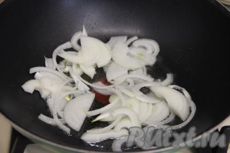 В сковороду влить растительное масло, дать ему хорошо погреться, уменьшить огонь до среднего. Выложить очищенный лук, нарезанный полукольцами, обжарить его в течение 4-5 минут (до прозрачности), время от времени перемешивая. 