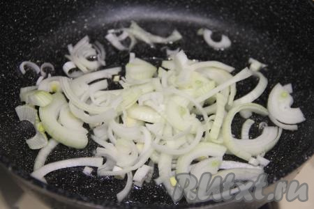 В сковороде разогреть растительное масло, выложить лук, нарезанный на тонкие полукольца (или четверть кольца). Обжарить лук, периодически помешивая, в течение 4-5 минут (до прозрачности) на среднем огне.