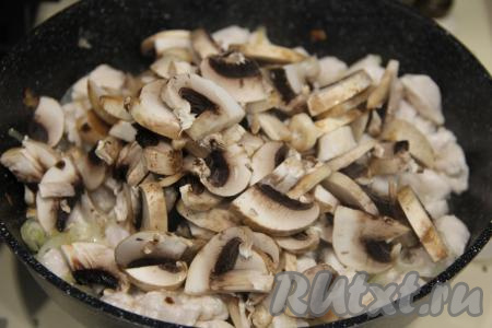 К мясу, обжаренному с луком, добавить шампиньоны, нарезанные на пластинки (или предварительно отваренные лесные грибы, нарезанные на небольшие части), перемешать, обжаривать 2-3 минуты, периодически перемешивая.&nbsp;