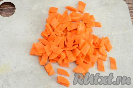 Добавить в кастрюлю очищенную морковку, нарезанную на небольшие брусочки.