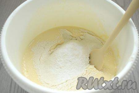 В получившуюся массу всыпаем разрыхлитель и 100 грамм просеянной муки, перемешиваем тесто для шарлотки лопаткой (или столовой ложкой), полностью вмешивая муку и при этом стараясь не сбить воздушность взбитых яиц.