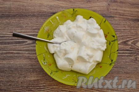 Затем достать из микроволновки, начать перемешивать нагревшееся маршмеллоу с помощью столовой ложки, беря зефирки со дна, разминая их и смешивая с водой.