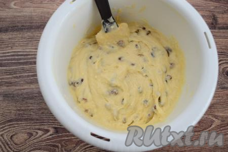 Вмешать изюм в тесто лопаткой, равномерно распределяя изюминки по всему тесту.