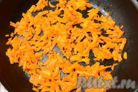 В сковороду влить растительное масло, хорошо его разогреть, выложить натёртую на крупной тёрке морковь. Обжарить морковку на среднем огне, иногда помешивая, до мягкости (около 5-6 минут).