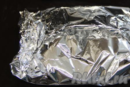 Завернуть рыбу с картошкой в фольгу, подвернув края. Выложить получившийся конверт из фольги на противень.