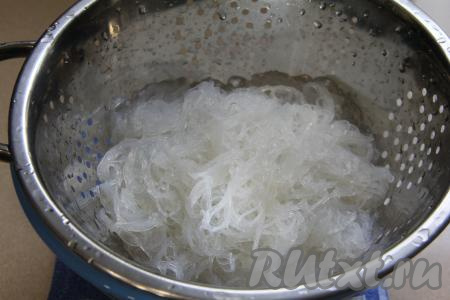 Откинуть фунчозу на дуршлаг, промыть холодной водой, лишней воде дать стечь. Нарезать фунчозу ножницами на более короткие части.