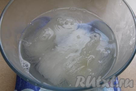 Пока овощи с грибами томятся, выложить фунчозу в глубокую миску, залить полностью кипящей водой и оставить на 5 минут.