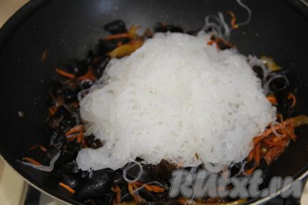 Выложить фунчозу в сковороду к древесным грибам и овощам.