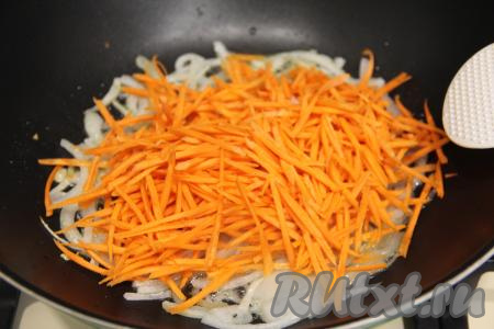 В глубокую сковороду влить растительное масло, хорошо его разогреть. Лук нарезать на полукольца и обжарить в течение 4 минут на среднем огне, иногда помешивая. Морковь натереть на тёрке для корейской моркови (или на крупной тёрке) и добавить в сковороду, перемешать.