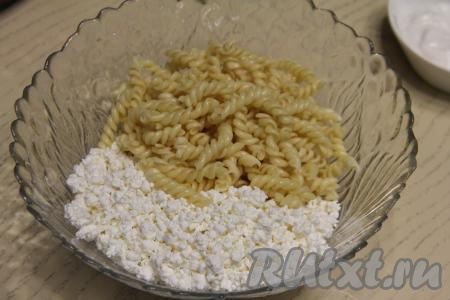 Дать варёным макаронам остыть, переложить в миску, добавить творог.
