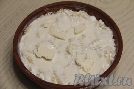 Получившуюся заливку влить в форму для выпечки поверх&nbsp;творожно-макаронной массы. Сверху выложить 30 грамм сливочного масла, нарезанного на кусочки.