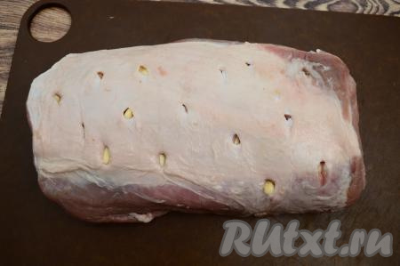 Глубокие надрезы нужно сделать со всех сторон карбоната, не забывая вставлять в каждый надрез по пластине чеснока. Надрезы нужны не только для чеснока, но и для того, чтобы свинина в дальнейшем хорошо промариновалась в соевом соусе.