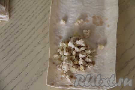 Ближе к одному узкому краю полоски из лаваша, немного отступая от краёв, выложить 1 столовую ложку мясной начинки.