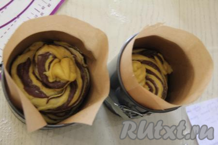 Свернуть каждую полоску теста в спираль. Поставить получившиеся спирали одна на другую и в таком виде поместить в форму для выпечки. Тесто должно заполнять форму чуть больше, чем на половину. Таким же образом сформировать второй краффин из оставшихся частей апельсинового и шоколадного теста, а также сливочного масла. Я для выпечки куличей использовала две металлические формы, застелив дно и бока форм пергаментом. Одна форма была диаметром 15 сантиметров, другая - 18 сантиметров.