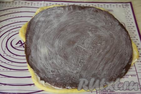 Поверх апельсинового пласта теста выложить шоколадный пласт теста и немного растянуть шоколадное тесто по апельсиновому. Смазать шоколадное тесто 25 граммами сливочного масла комнатной температуры.