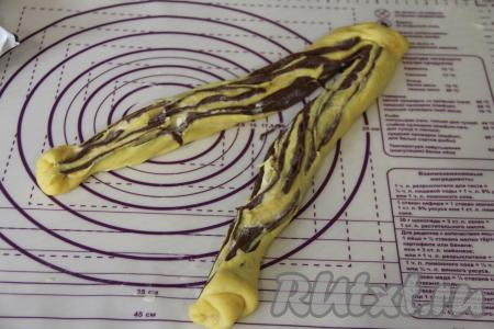 Разрезать рулет вдоль на две части, слегка не дорезая до конца. Получатся две полоски теста.