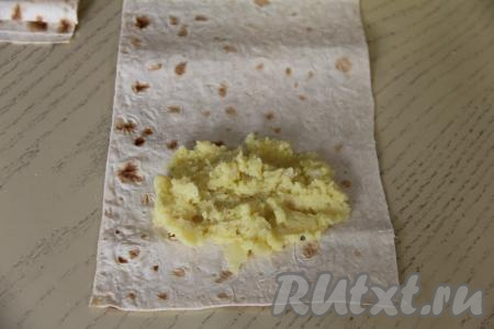 Нарезать лаваш на прямоугольники размером 16 сантиметров на 23 сантиметра. У меня получились 8 прямоугольников. Начинку сразу зрительно разделить на столько частей, сколько полосок из лаваша у вас получилось (я разделила картофельную начинку на 8 частей). Ближе к узкому края прямоугольника из лаваша, не забывая отступить от краёв лаваша, выложить одну часть начинки.