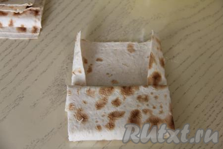 Подвернуть длинные края лаваша на начинку и свернуть лаваш,&nbsp;начиная с края с начинкой, в прямоугольный пирожок.