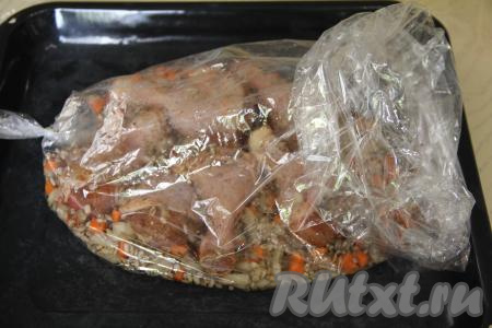 Перемешать перловку с овощами и курицей. Рукав для запекания выложить на противень. В рукав выложить кусочки курицы, смешанные с перловкой и овощами. Влить в рукав 400 миллилитров воды.