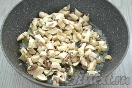 К обжаренному луку добавляем шампиньоны (или предварительно отваренные лесные грибы), нарезанные на небольшие кубики, перемешиваем. Обжариваем лук с грибами минут 6-7 (до выпаривания жидкости из грибов), иногда перемешивая. Солим грибы, обжариваем 1 минуту.&nbsp; Убираем с огня.