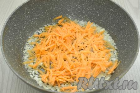 К обжаренному луку выкладываем натёртую на крупной тёрке морковь, перемешиваем овощи и обжариваем их минут 5 (до мягкости морковки), время от времени перемешивая.