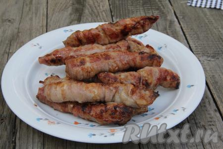 Готовое куриное филе в беконе переложить с решётки мангала на тарелку.