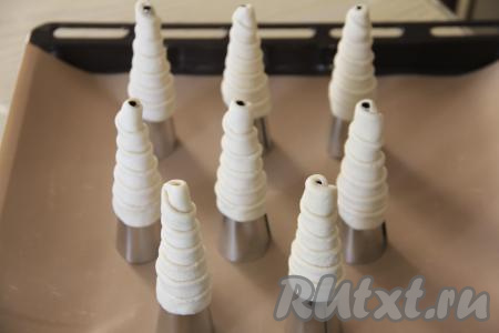 Слоёное тесто я нарезала на 8 полосок, поэтому сформировала 8 заготовок для трубочек, обернув внахлёст каждую полоску вокруг конуса. Поставить трубочки, как на фото, на противень, застеленный ковриком (или бумагой) для выпечки.&nbsp;