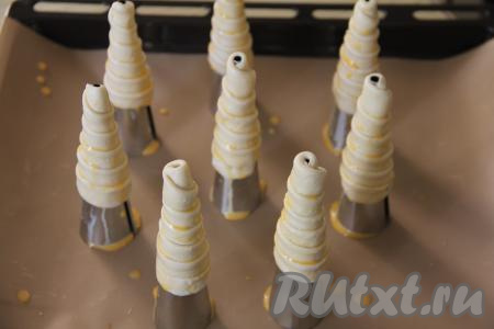 В небольшой ёмкости яичный желток взбить вилкой. Смазать заготовки трубочек взбитым желтком и поставить в разогретую до 220 градусов духовку.