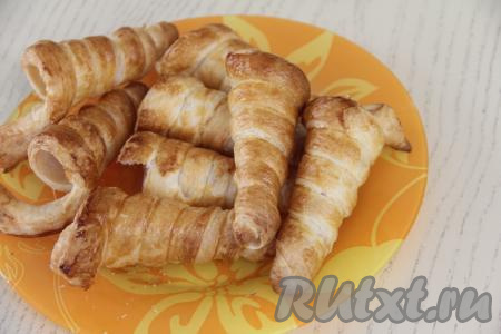 Достать готовую выпечку из духовки. Слегка остудить трубочки на конусе. А затем аккуратно снять трубочки с конусов. Полностью остудить трубочки из слоёного теста.