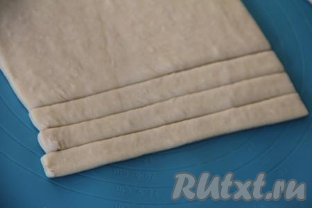 Разморозившийся пласт слоёного теста, не раскатывая, разрезать на 8 полосок шириной примерно 1,5 сантиметра.