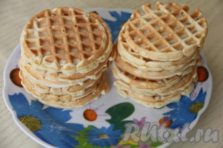 Переложить готовую вафлю на тарелку. Периодически перемешивая тесто для вафель и смазывая вафельницу растительным маслом только по мере необходимости (я после выпечки первой вафли больше вафельницу маслом не смазывала), постепенно испечь все вафли, складывая их на тарелку.