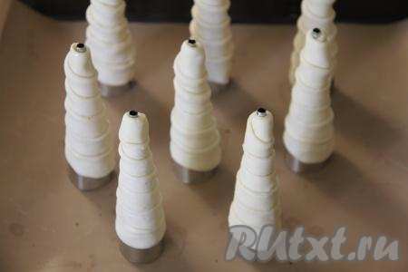 Когда полоска закончится, хорошо закрепить край теста. Аналогично из оставшихся 7 полосок теста сформировать ещё 7 заготовок трубочек, наматывая слегка внахлёст полоски теста на трубочки и хорошо закрепляя край полоски. Конусы, обмотанные тестом, поставить, как на фото, на противень, заранее застеленный ковриком (или бумагой) для выпечки.&nbsp;