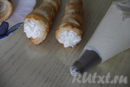 Трубочки из слоёного теста наполнить творожным кремом. Если нет кулинарного мешка, можно наполнить трубочки кремом с помощью ложки.