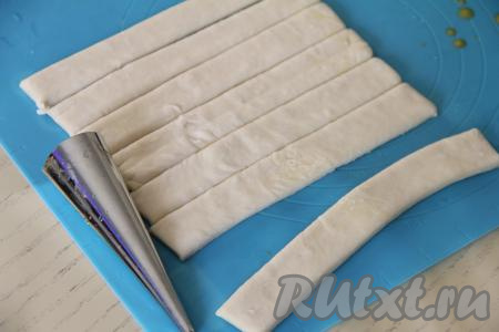 Размороженный пласт слоёного теста, не раскатывая, нарезать на 8 полосок шириной ориентировочно 1,5 сантиметра.&nbsp;