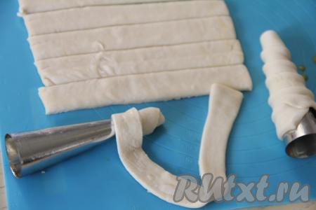 Формировала трубочки я с помощью металлических конусов, купленных в магазине. Металлические конусы немного смазать растительным маслом, это нужно делать для того, чтобы готовые трубочки лучше отделялись от конусов. Вначале одну полоску теста, слегка растягивая её руками, намотать немного внахлёст на конус, начиная с узкой стороны конуса.