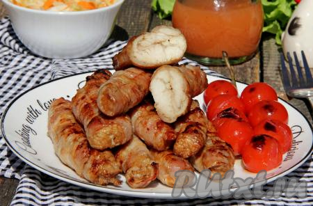 Готовые аппетитные, ароматные, сочные рулетики из индейки в беконе снять с мангала, переложить на тарелку и сразу же подать к столу.