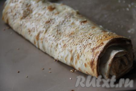 Запекать рулет из лаваша с творогом и сыром в духовке, разогретой до 200 градусов, 15 минут.