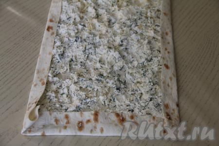 Вначале подвернуть более узкий край лаваша на начинку. Затем подвернуть длинные края лаваша на начинку, как на фото.&nbsp; 