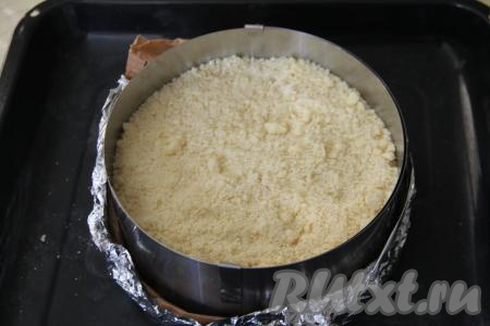 Поверх творожной начинки равномерно распределить оставшееся тесто-крошку, закрывая всю начинку.